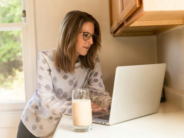 Woman standing with her computer at her desk